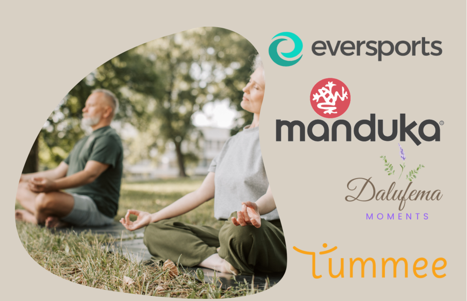 Zwei Personen meditieren im Freien, umgeben von Natur. Logos von Manduka und Eversports.