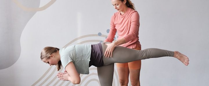 Yogalehrerin unterstützt im Einzeltraining bei einer Yogaposition in einem hellen Raum.
